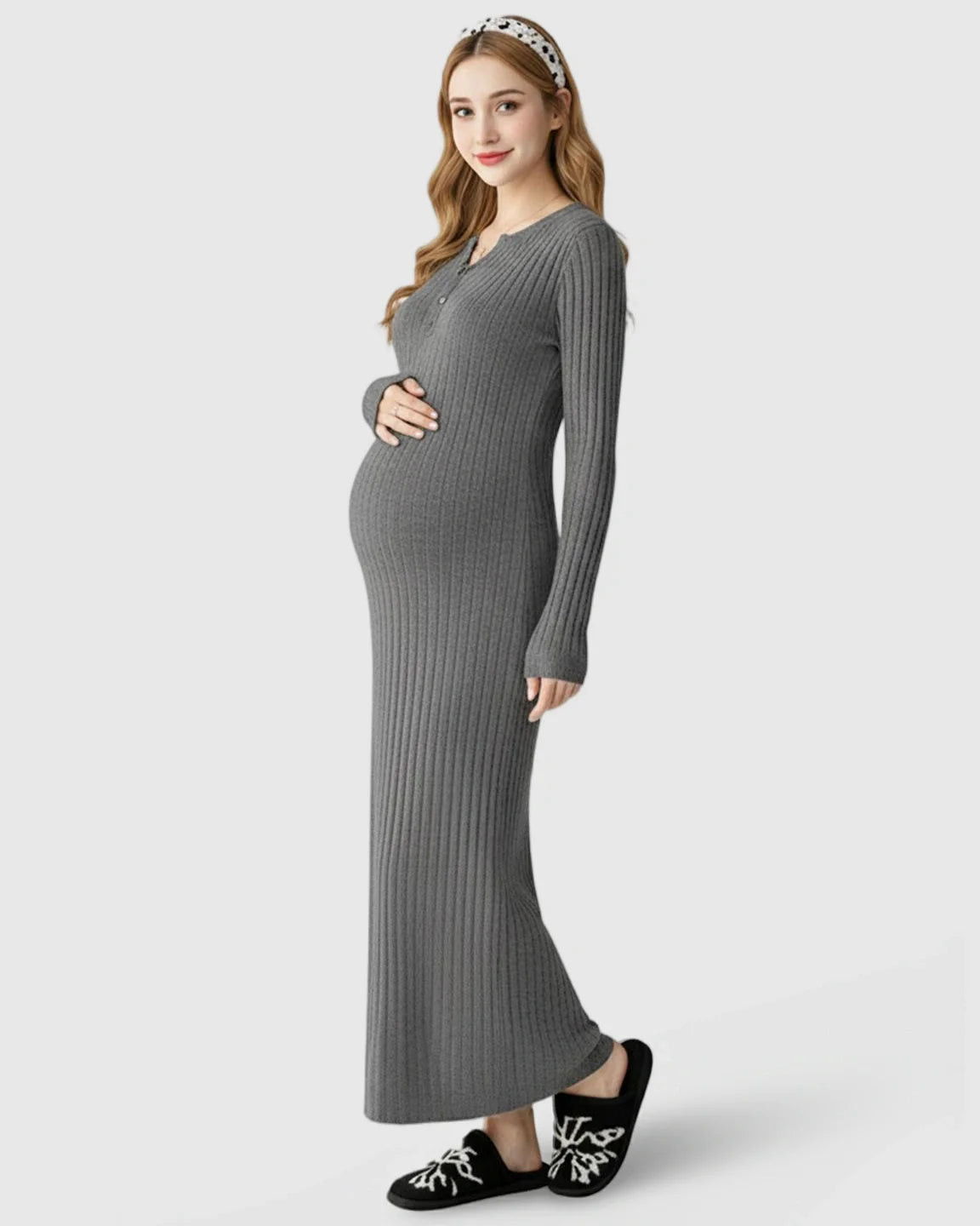 Pregnant woman in a gray ribbed knit A-line long sleeve maternity maxi dress, holding her bump.