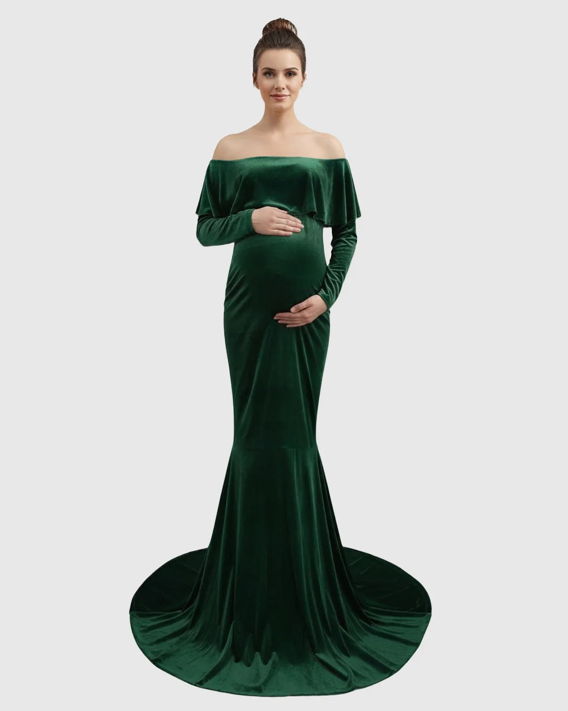Elegant emerald green velvet off-shoulder maternity gown with a flowing train, highlighting a pregnant woman's bump.