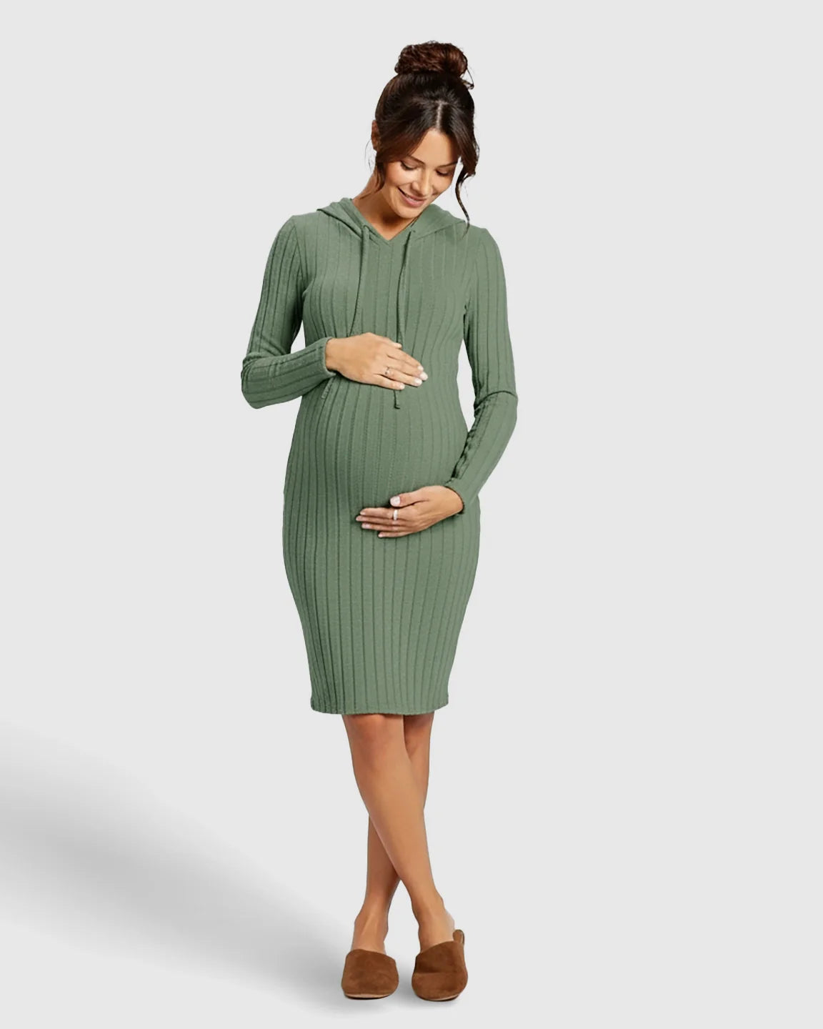 Pregnant woman in a green ribbed bodycon hooded maternity midi dress, gently holding her bump.