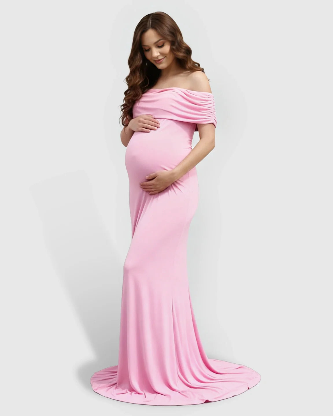 Pregnant woman in a pink off-shoulder bodycon maternity mermaid gown, cradling her bump.