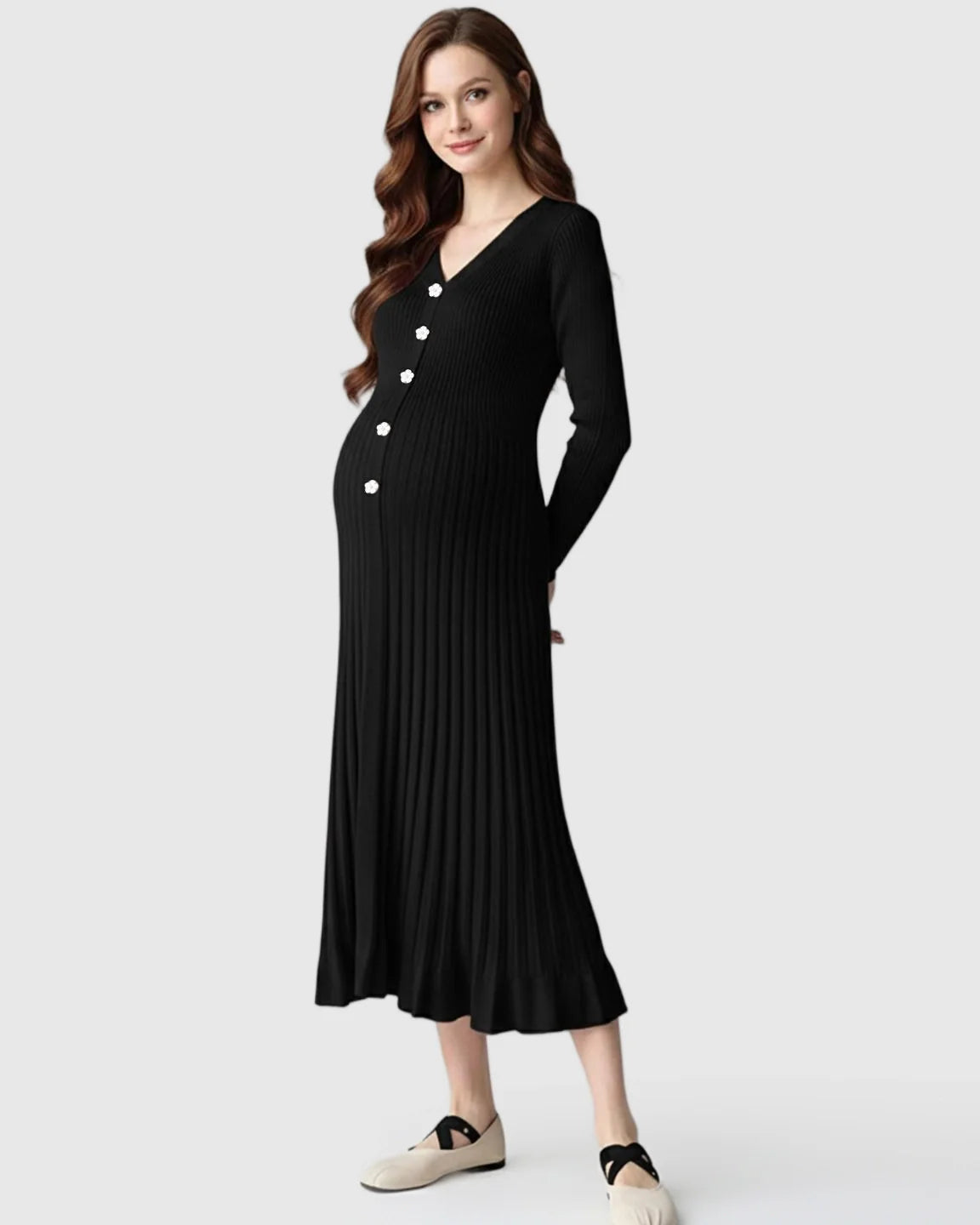 Pregnant model in a black ribbed knit long-sleeve maternity midi dress with white floral buttons.