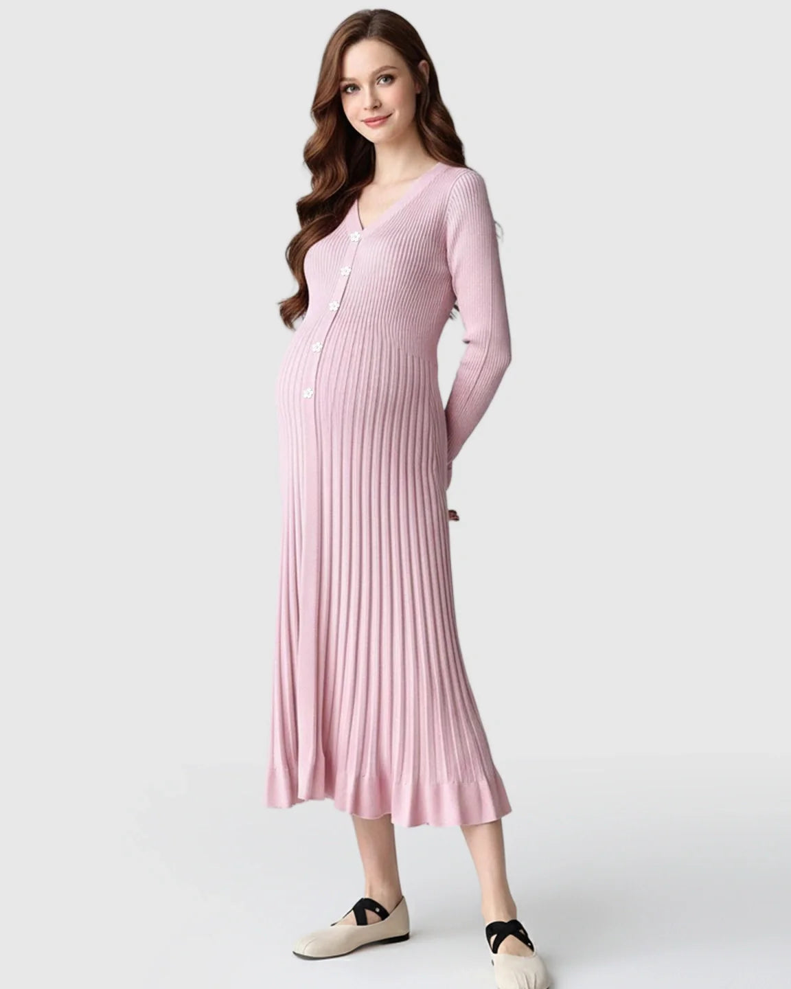 Smiling pregnant woman in a pink ribbed knit maternity midi dress with long sleeves and a V-neck.