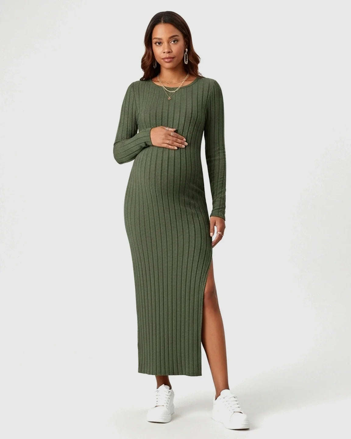 Pregnant woman in a green ribbed knit long-sleeve maternity maxi dress with a high side slit.