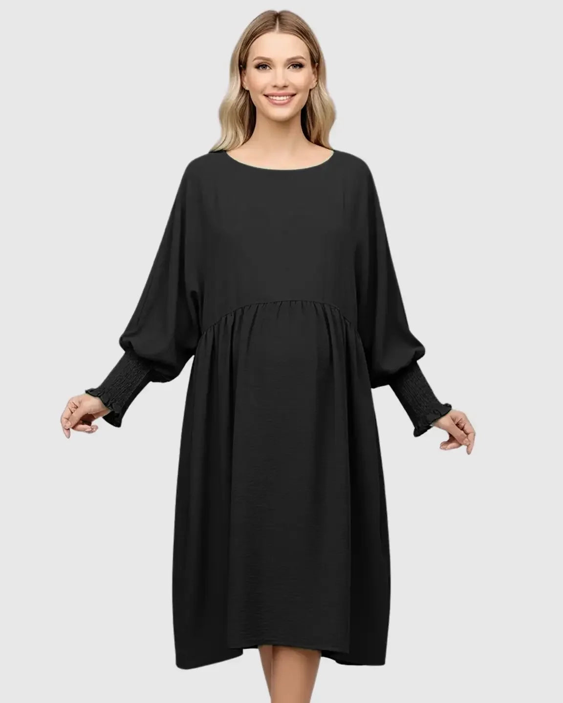 Smiling pregnant woman in a black smocked sleeve casual dress with a round neckline and drawstring waist.