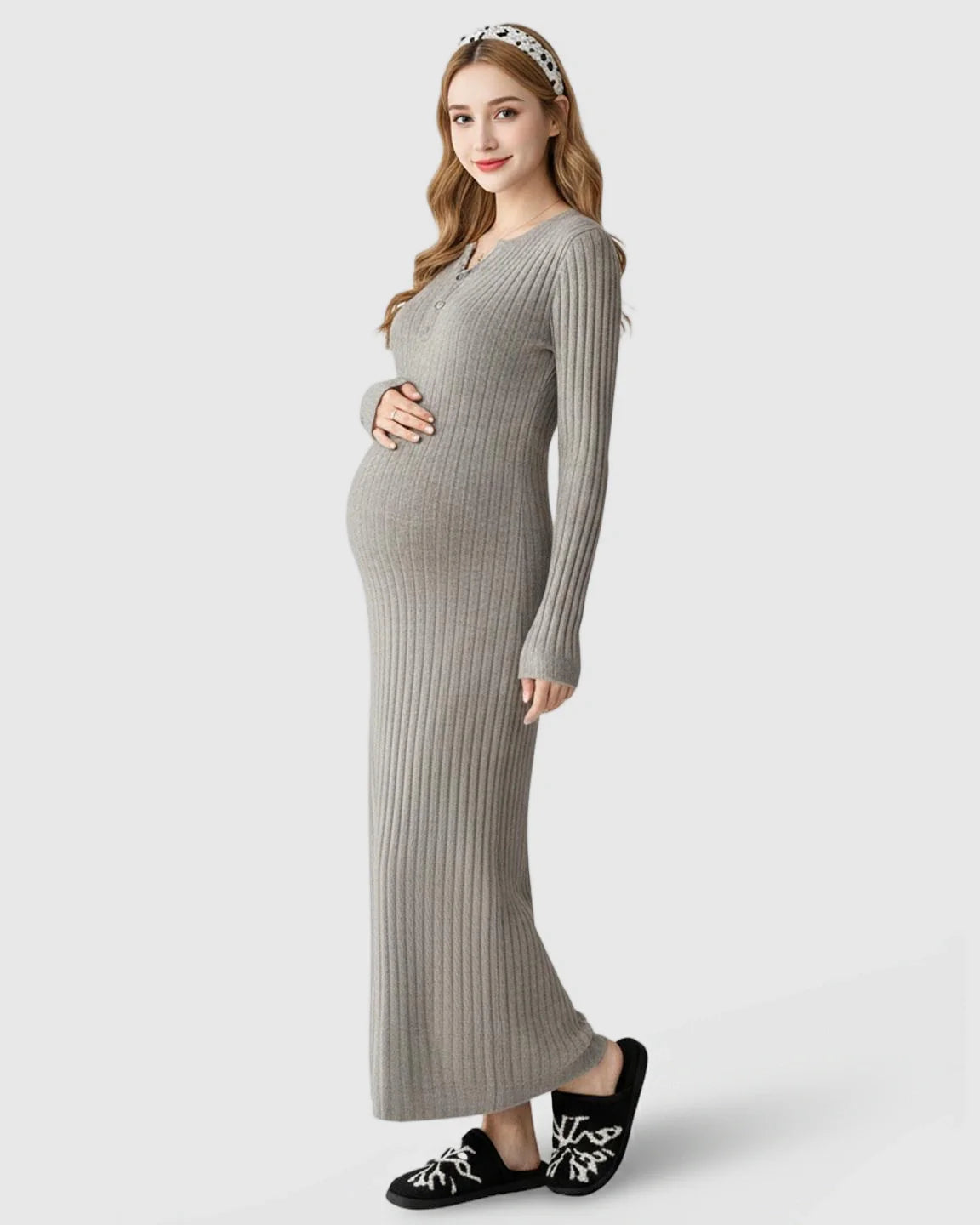 Pregnant woman in a gray ribbed knit A-line long sleeve maternity maxi dress, holding her bump.