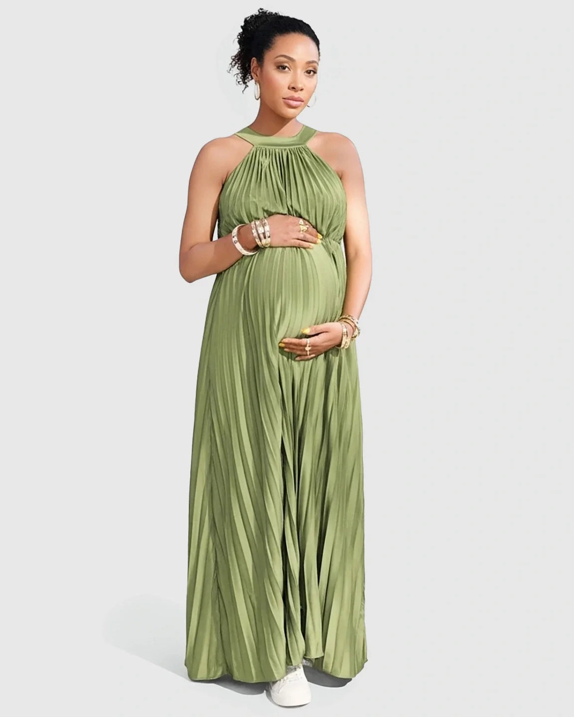 Pregnant woman in a sage green pleated faux silk halter neck maternity maxi dress.
