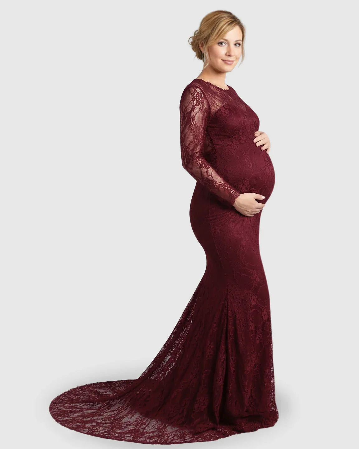 Pregnant woman in a long-sleeved, sheer lace trumpet maternity gown in a rich burgundy color.