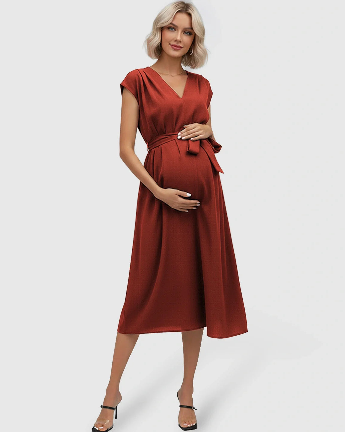 Pregnant woman in a rust-colored V-neck maternity midi dress with flutter sleeves and an adjustable tie-waist.