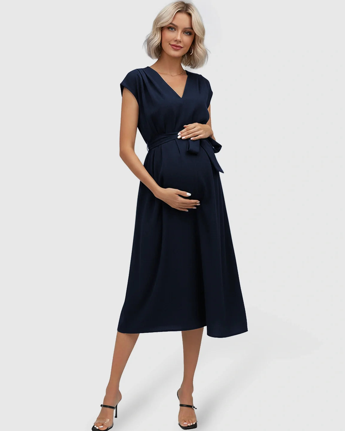 Navy tie-waist V-neck maternity midi dress with flutter sleeves, worn by a pregnant woman.