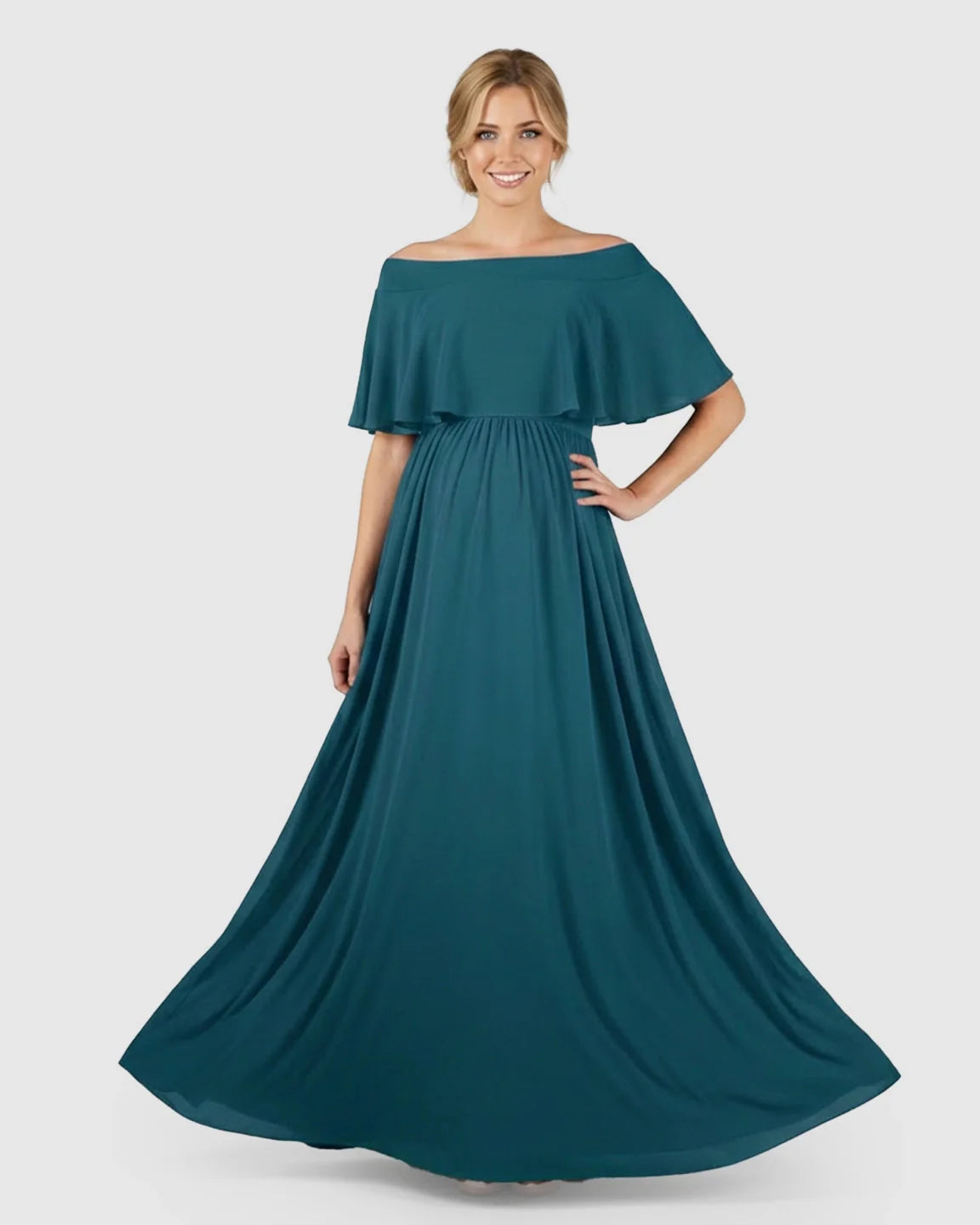 Smiling pregnant woman in a teal chiffon off-shoulder bohemian maternity photoshoot dress with a flowy silhouette.