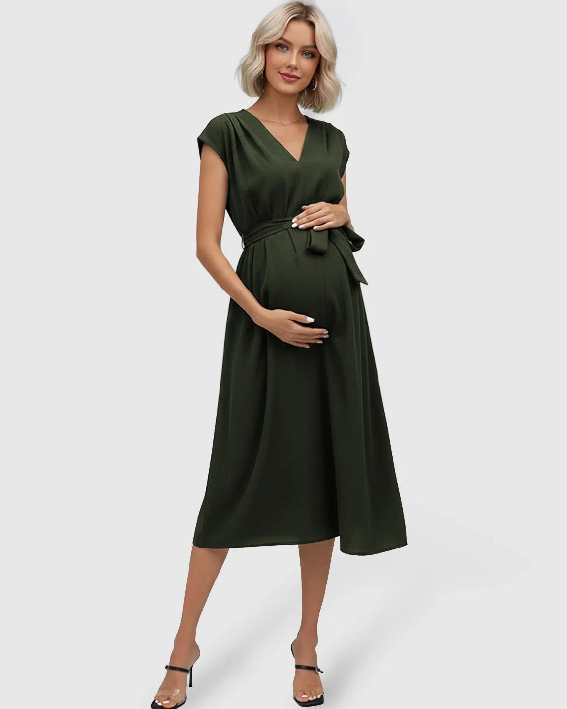 Pregnant woman in a dark green V-neck maternity midi dress with flutter sleeves and a tie-waist.