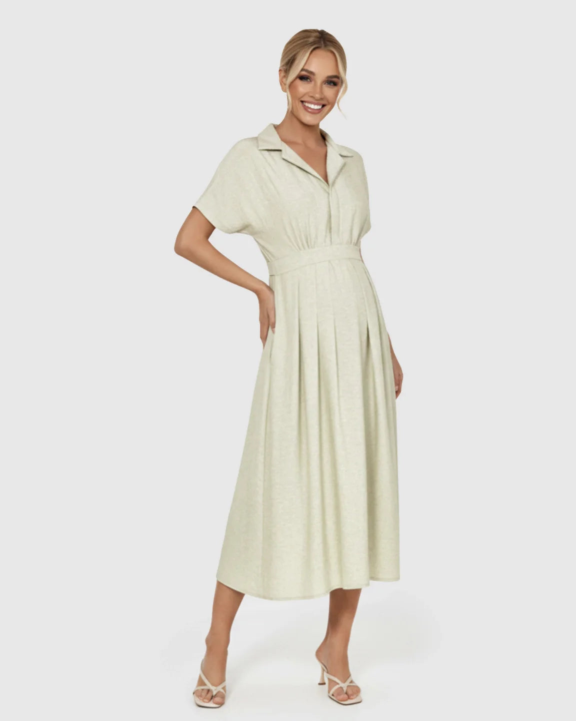 Smiling woman in a light green lapel collar A-line maternity midi dress with a belted waist and short sleeves.