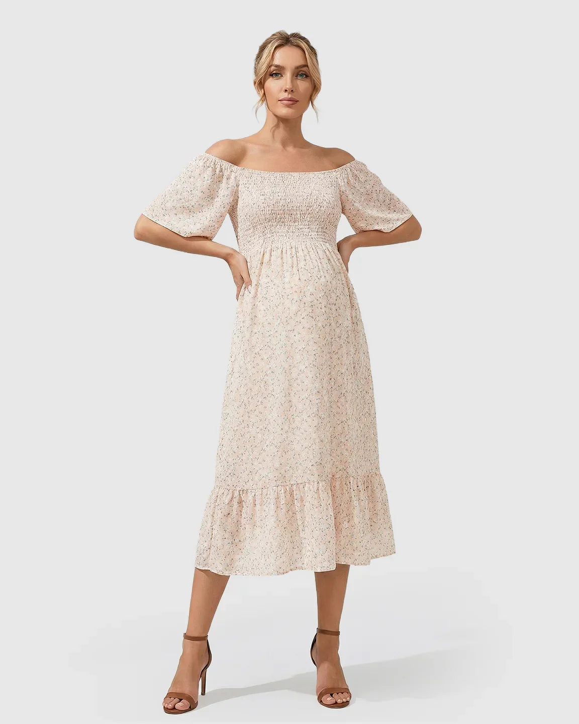 Blonde pregnant woman in a light pink floral off-shoulder smocked maternity midi dress with flutter sleeves.
