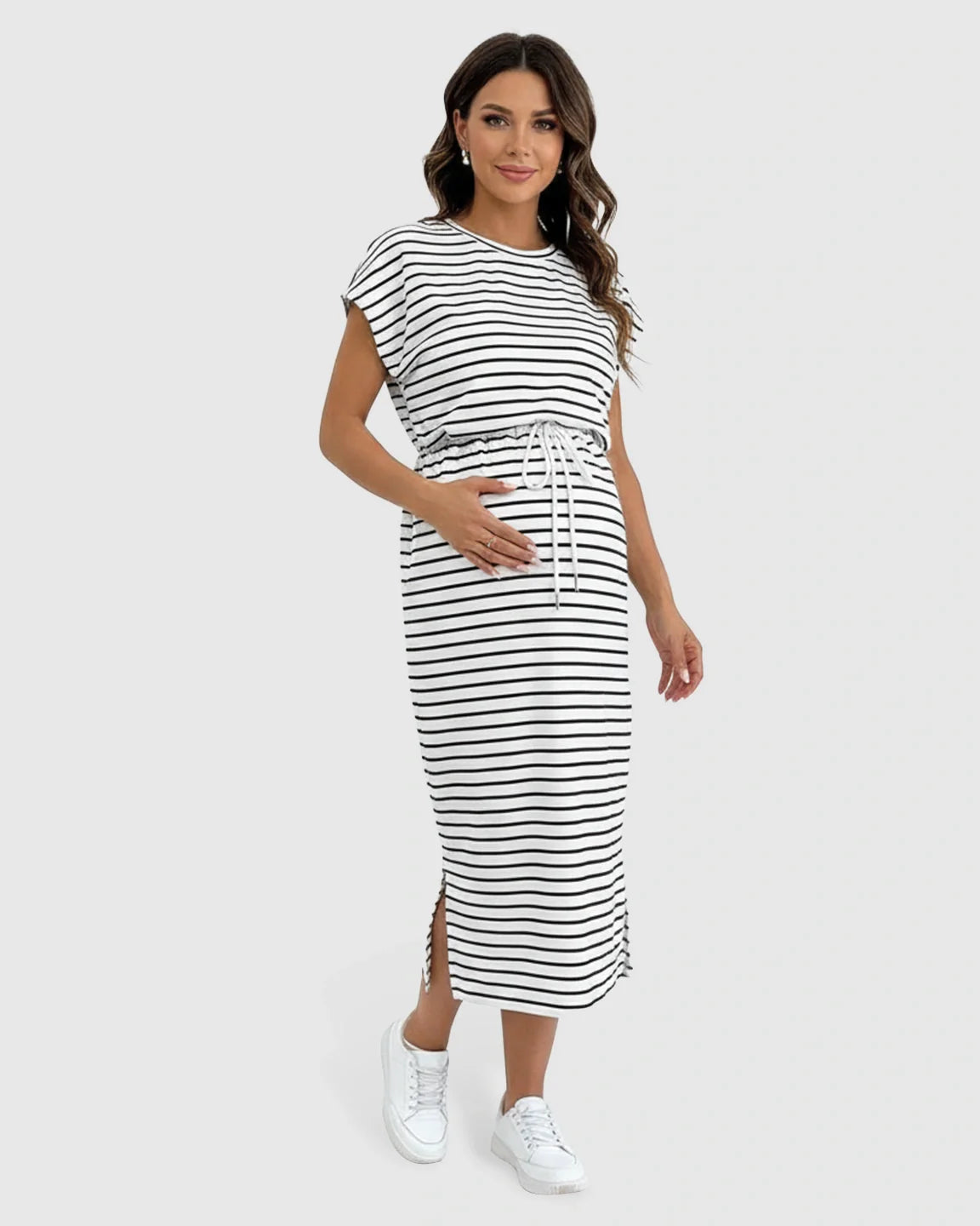 Pregnant woman in a black and white striped cap sleeve maternity midi dress with adjustable waist and side slits.