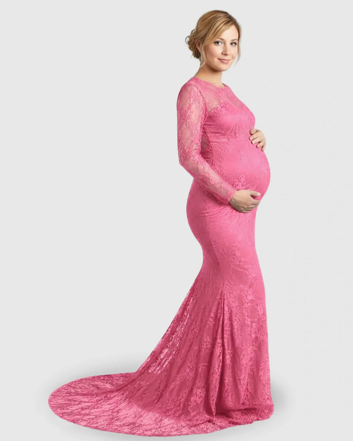 Pregnant model in a pink sheer lace trumpet maternity photoshoot gown with long sleeves and a mermaid skirt.