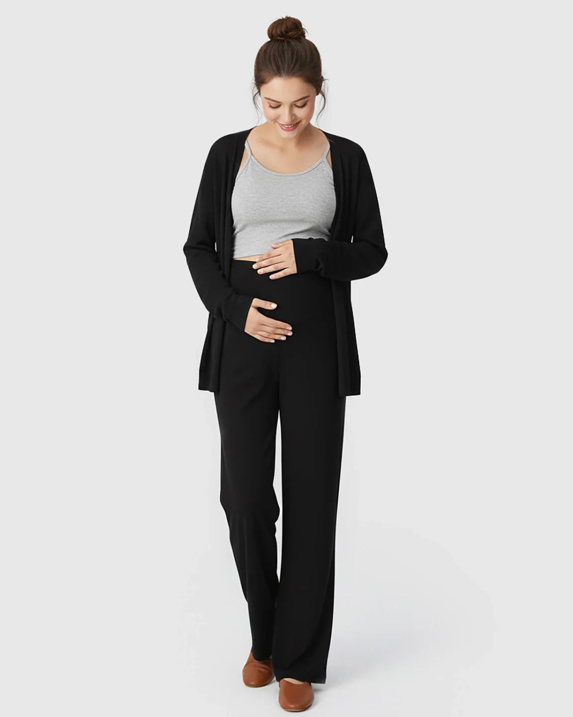Pregnant woman in black crossover waist wide-leg maternity lounge pants, grey tank, and black cardigan.