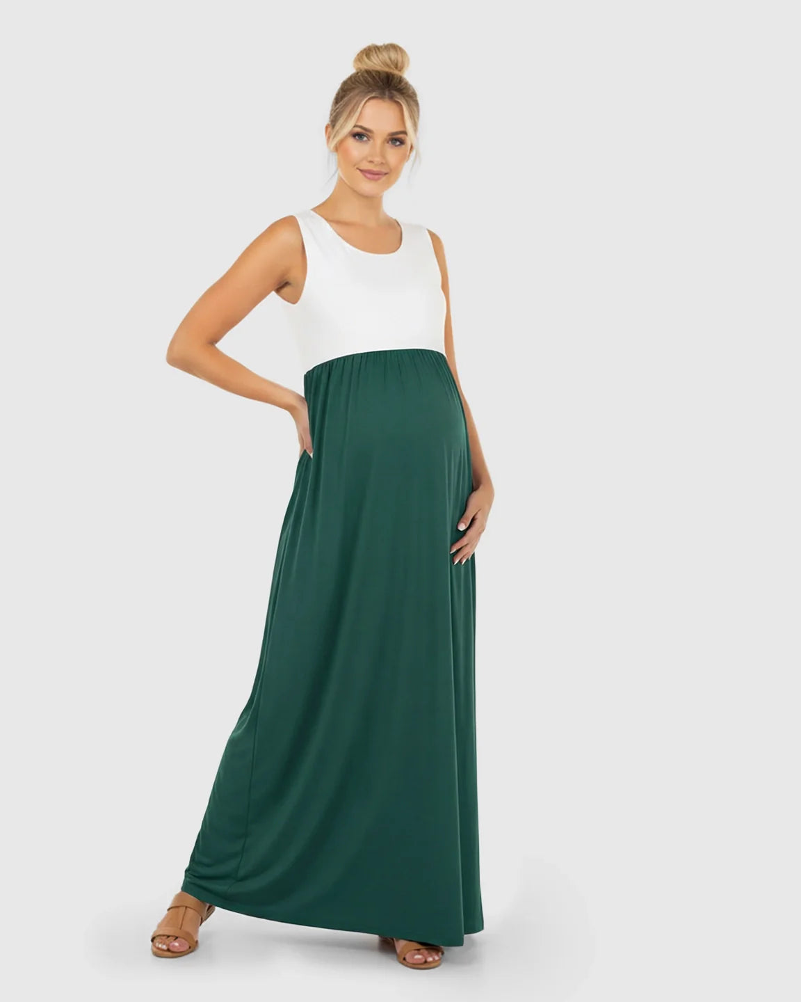 Smiling pregnant woman in a white and dark green colorblock high-waisted maternity maxi dress.