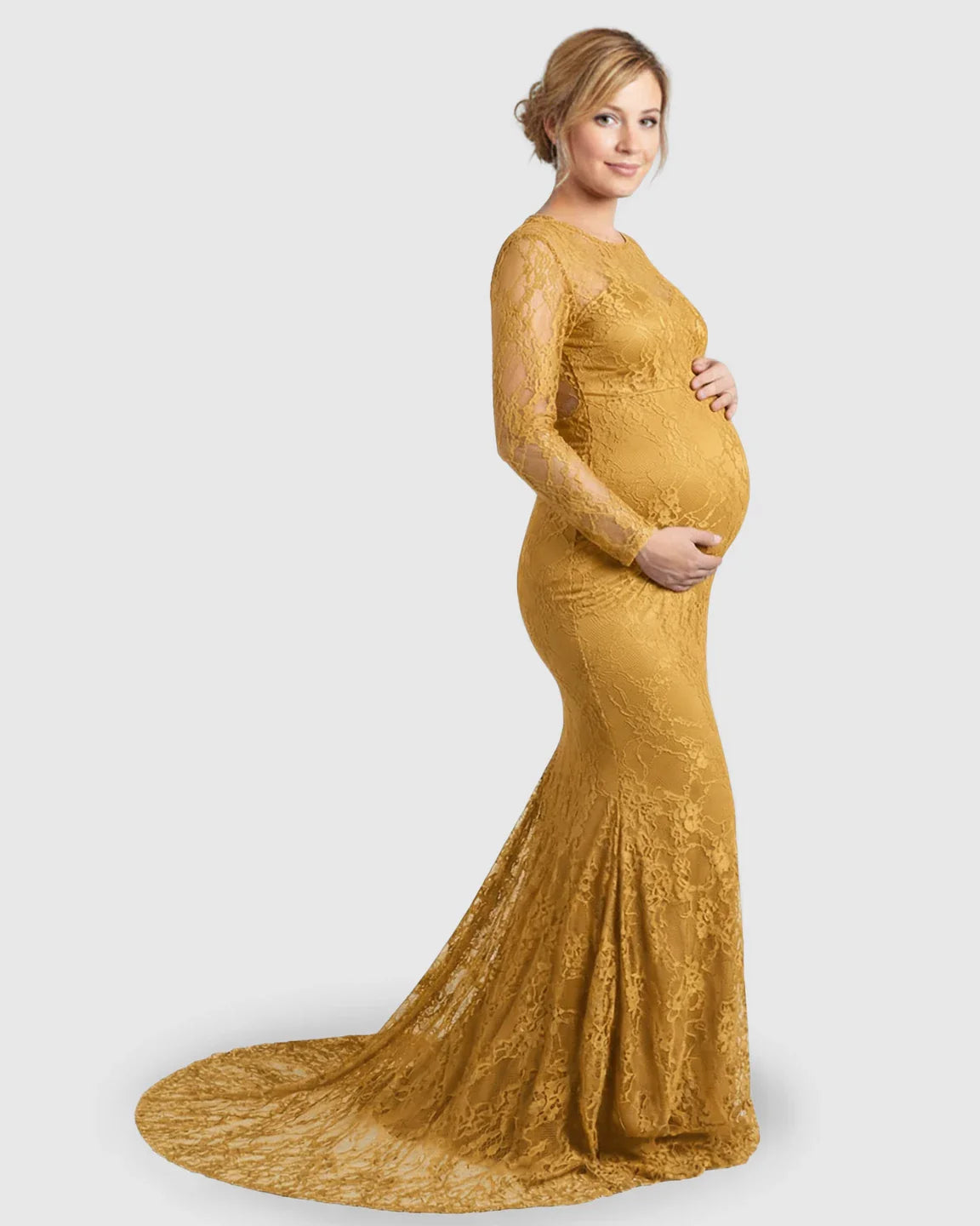 Pregnant woman in a gold sheer lace trumpet maternity gown with long sleeves and a mermaid-style skirt.