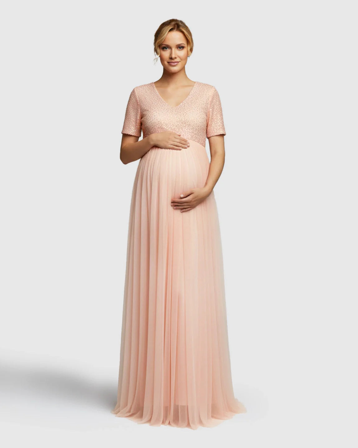Pink sequin A-line maternity evening gown with V-neck, short sleeves, and flowing mesh skirt.