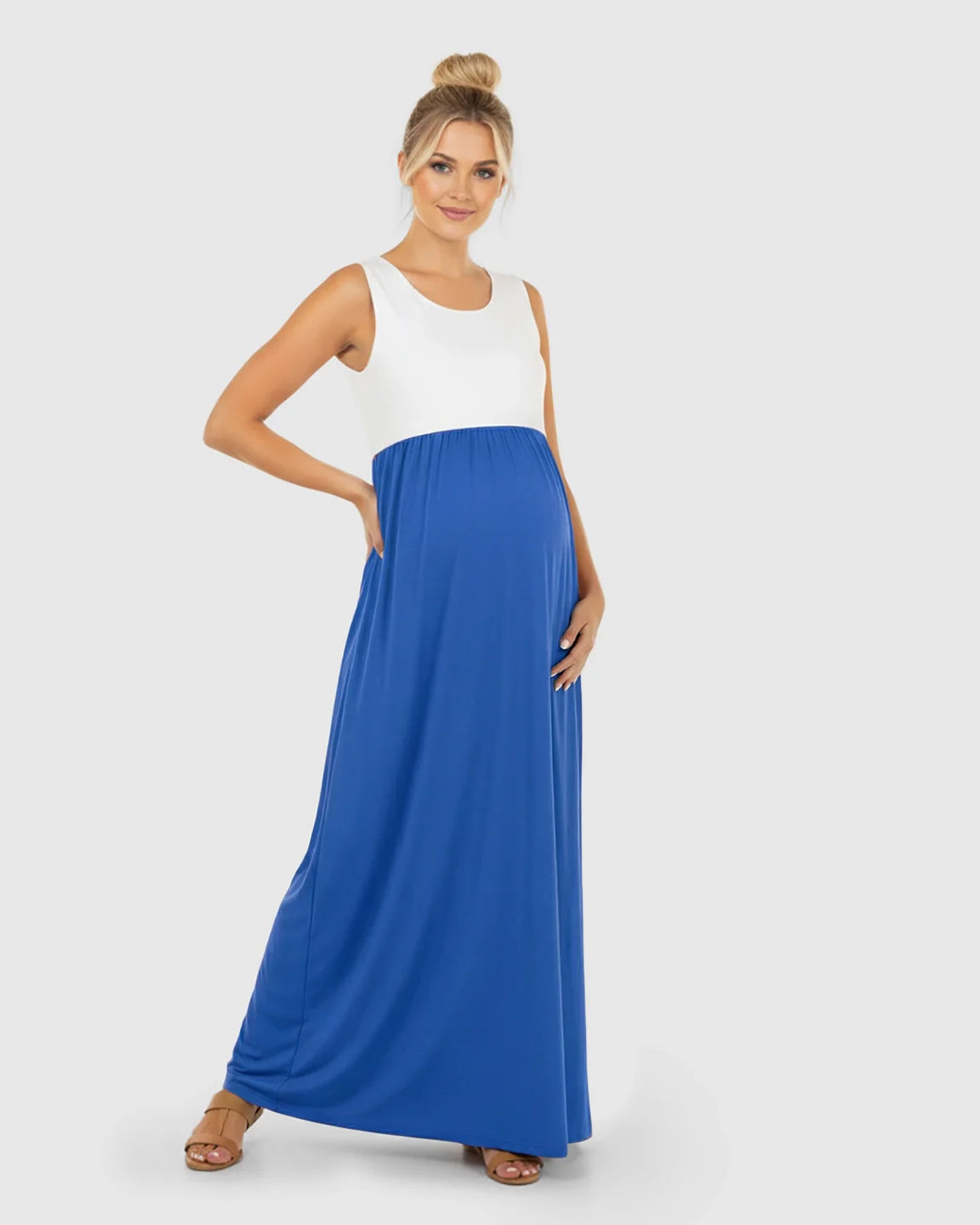 Smiling pregnant woman in a white and blue colorblock high-waisted maternity maxi dress.
