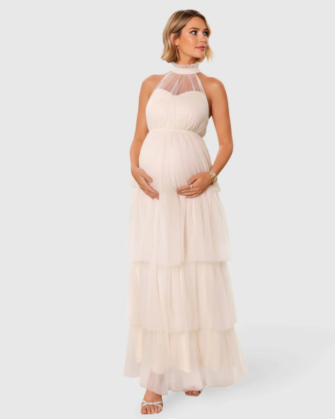 Maternity gown: Halter neck, tiered mesh, floor-length, light cream, flowing fabric.