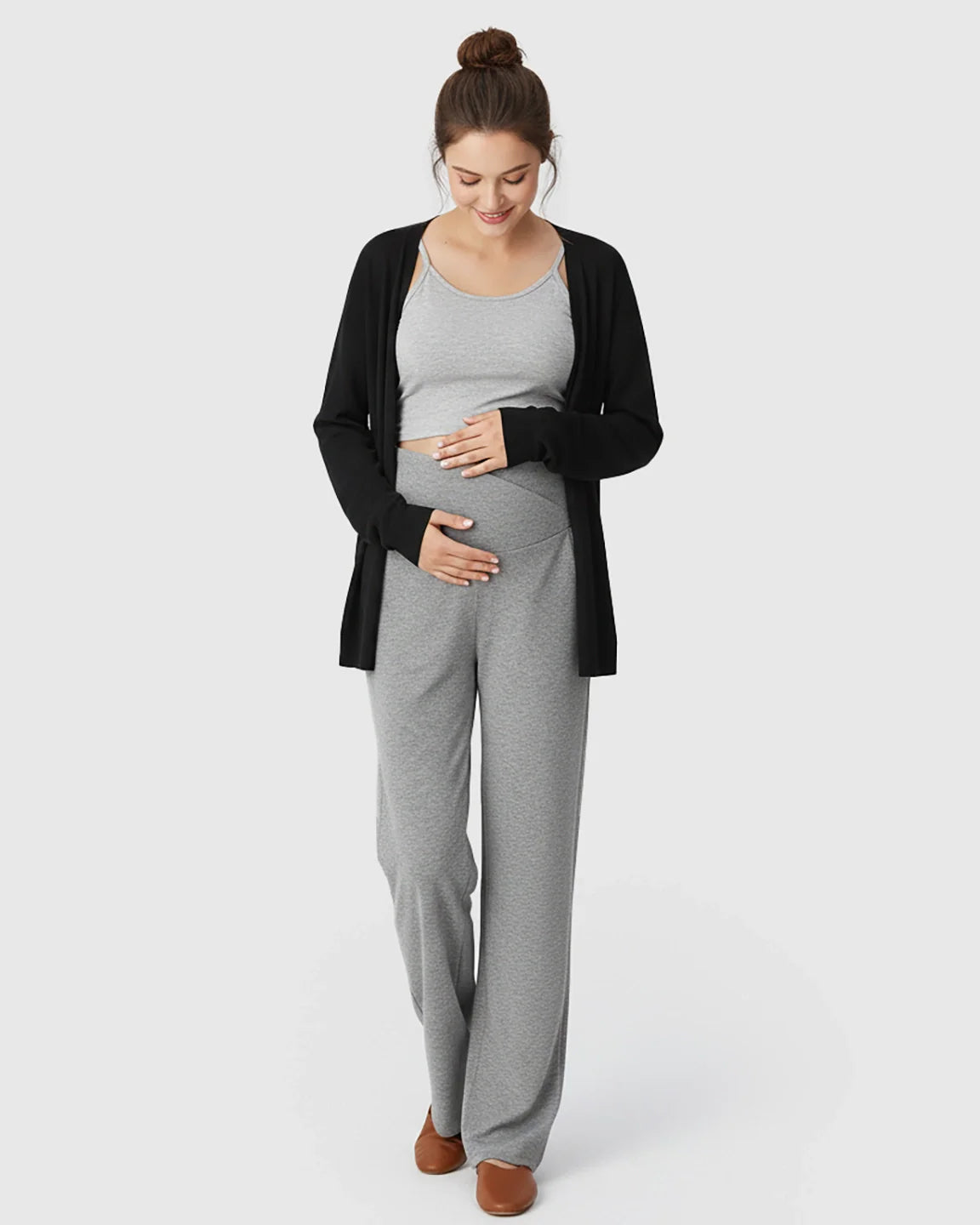 Pregnant woman in gray crossover waist wide-leg maternity lounge pants, gray tank, and black cardigan.