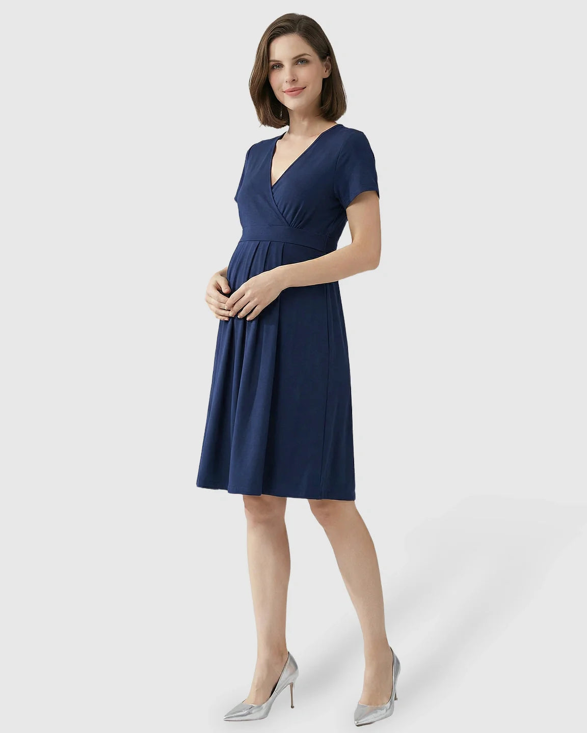 Woman in a navy V-neck A-line maternity and nursing dress with short sleeves, smiling.