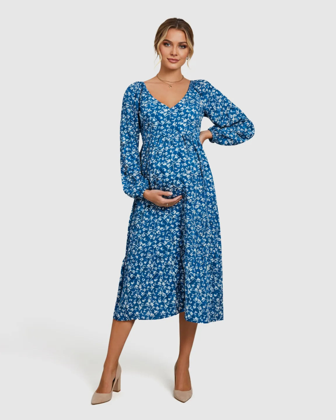 Maternity model in a blue floral chiffon balloon-sleeve A-line dress with a V-neck, holding her bump.