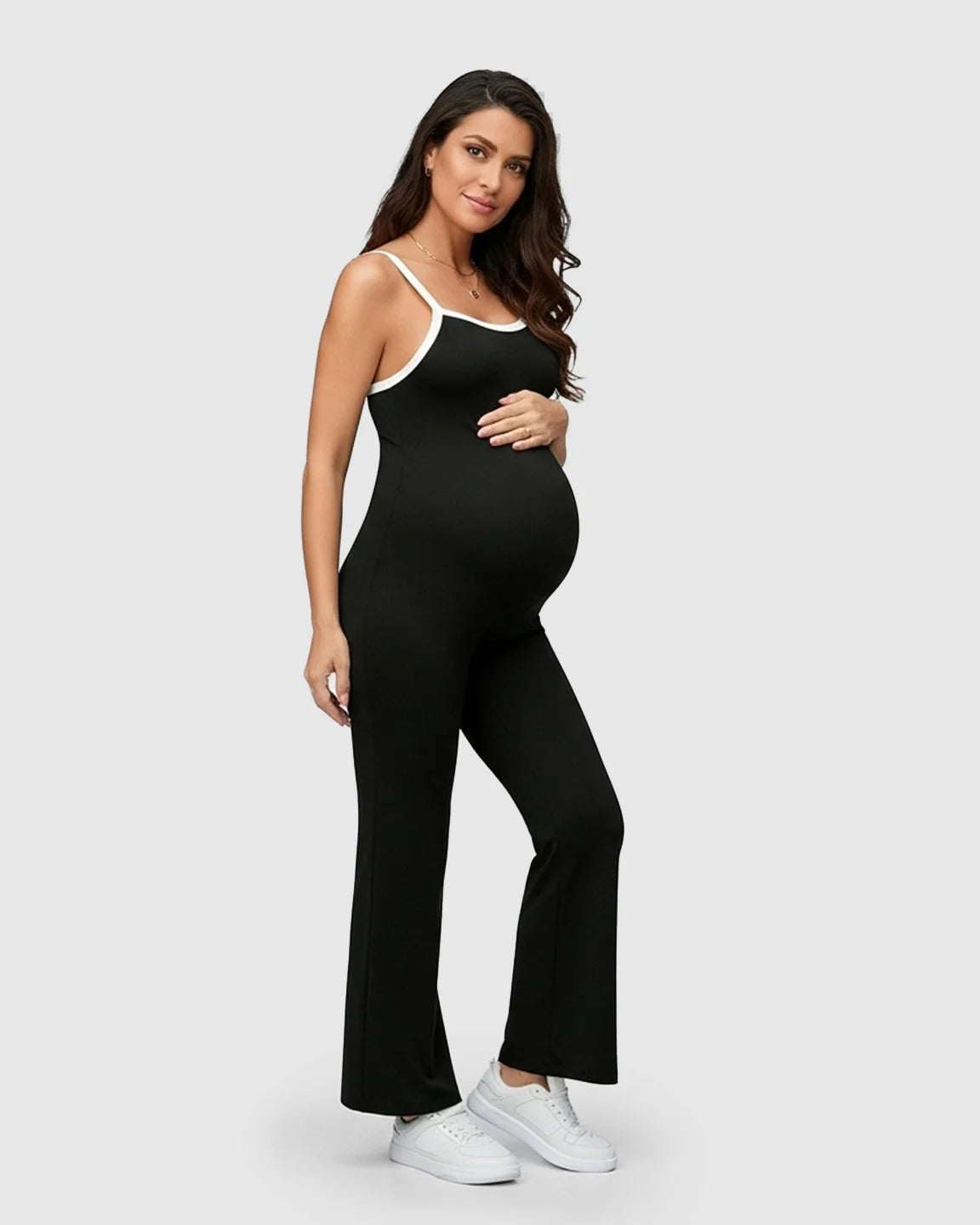 Maternity model in black sleeveless jumpsuit with white trim, soft stretch fabric, and relaxed fit.