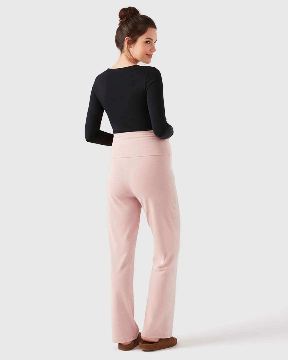 Woman wearing pink fleece relaxed maternity pants with an over-belly waistband and wide-leg silhouette.