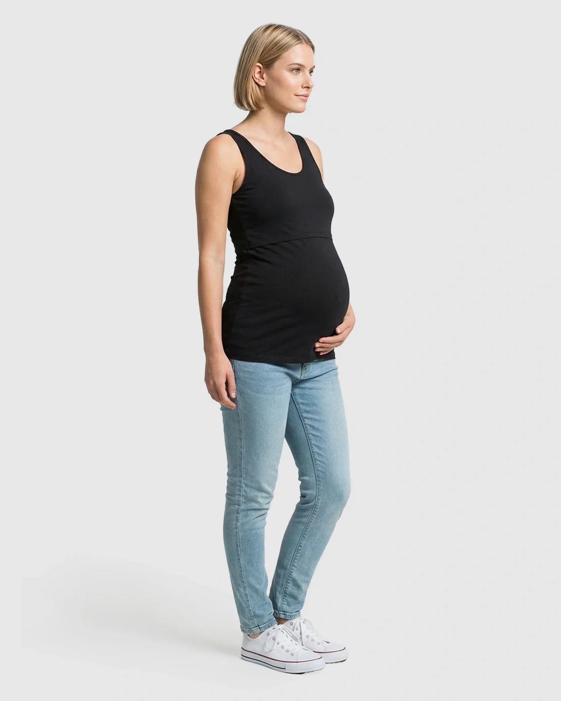Pregnant woman in black stretch nursing-access maternity tank top and jeans.