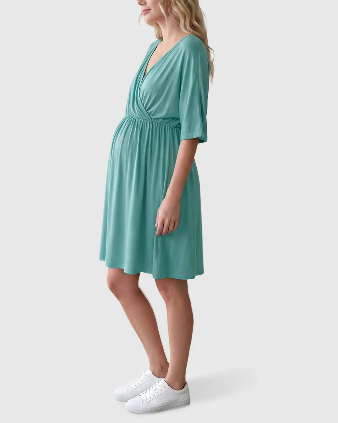 Pregnant woman in a mint green cross-front maternity midi dress with 3/4 sleeves and a flowy A-line silhouette.