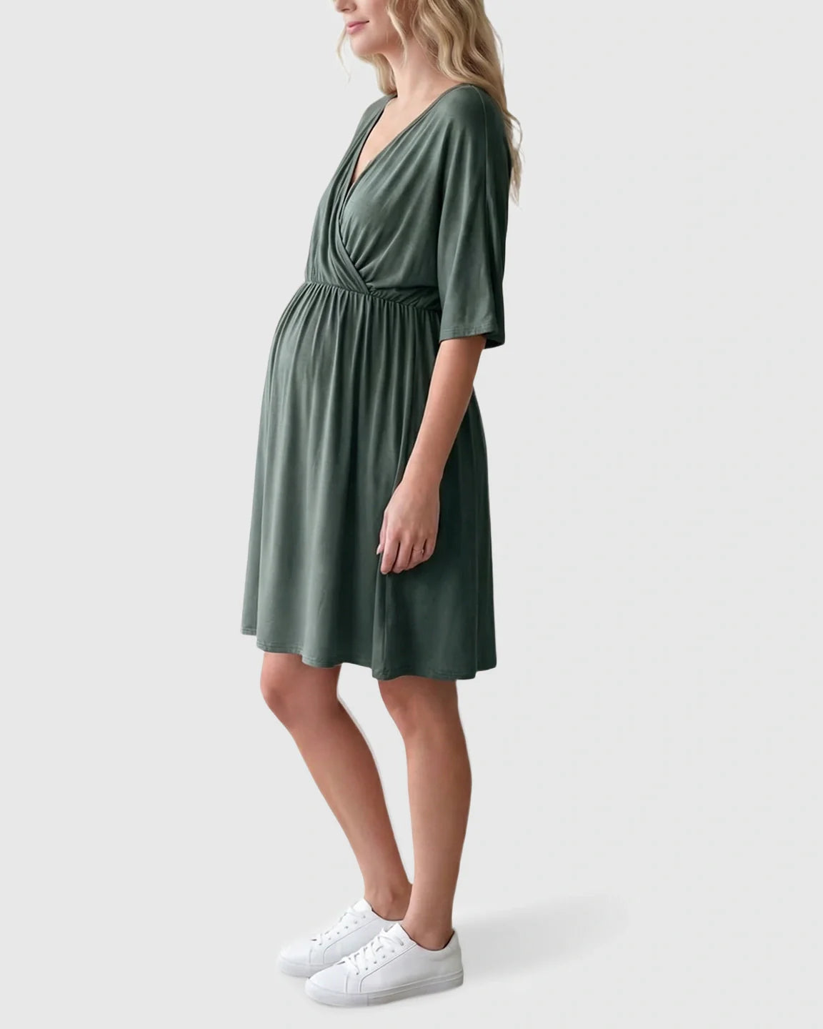 Pregnant woman in a sage green cross-front maternity midi dress with 3/4 sleeves and a flowy A-line silhouette.