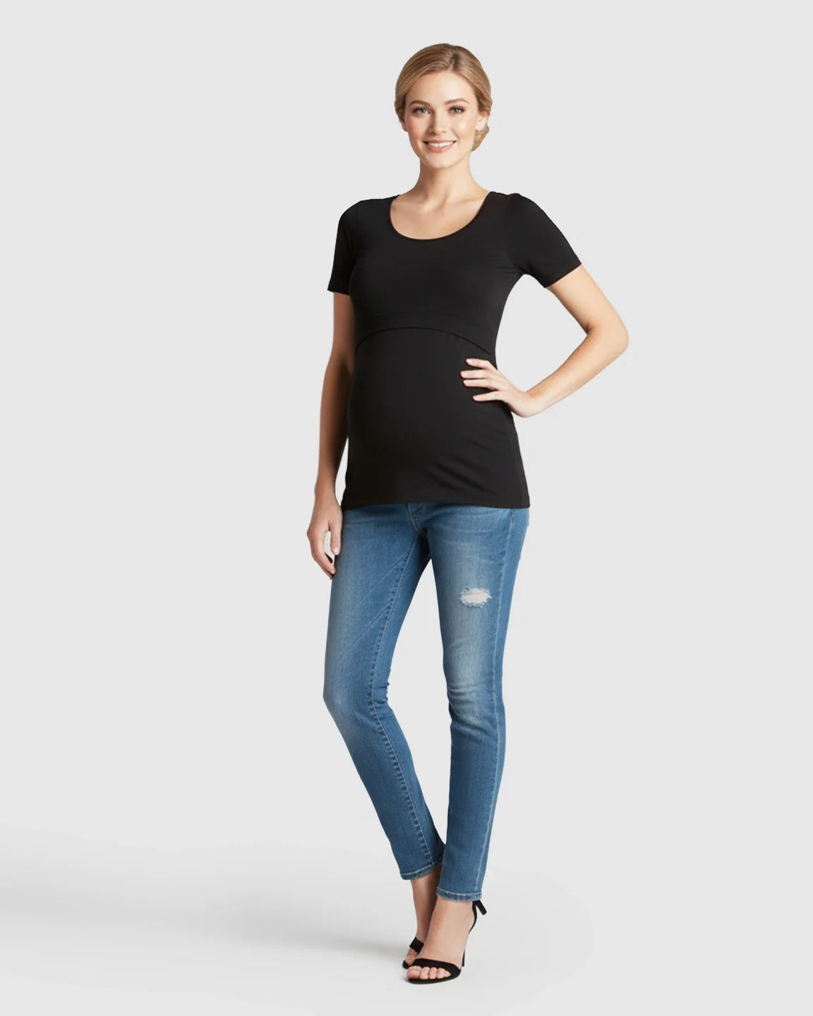 Smiling pregnant woman in a black stretch-fit V-neck nursing t-shirt and jeans.