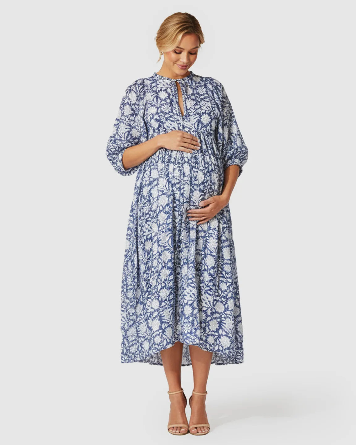 Pregnant woman in a blue and white floral loose-fit maternity midi dress with gathered shoulders and puff sleeves.