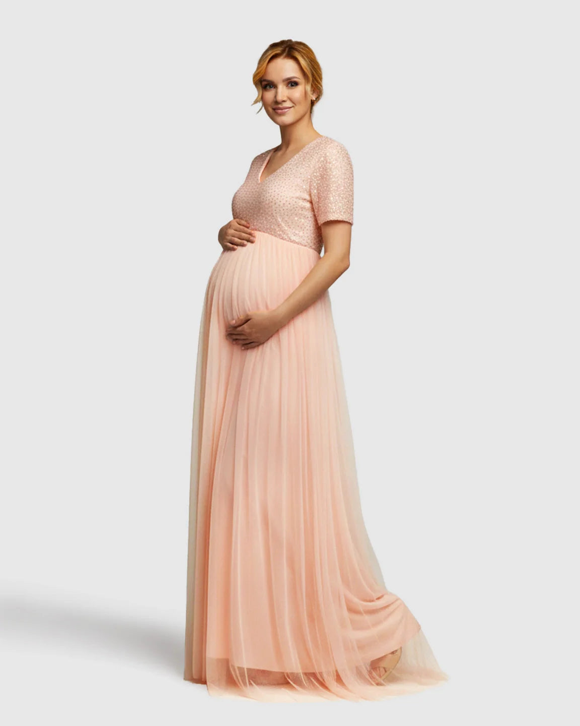Pink sequin A-line maternity evening gown with V-neck, short sleeves, and flowing mesh skirt.
