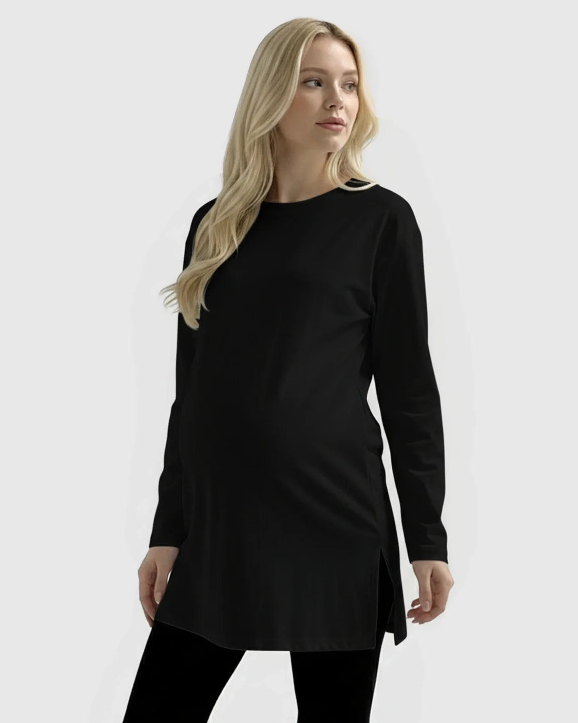 Blonde pregnant woman wearing a black long-sleeve soft cotton maternity top with side slits.