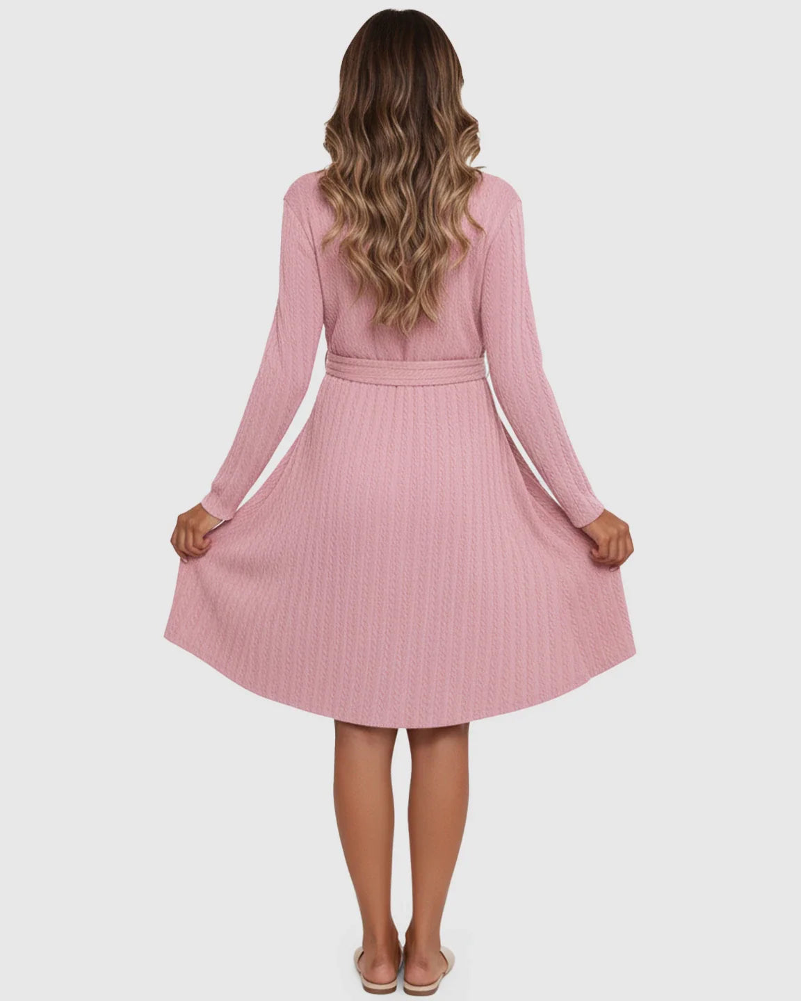 Back view of a woman in a pink ribbed tie-waist maternity midi dress with long sleeves and an A-line skirt.