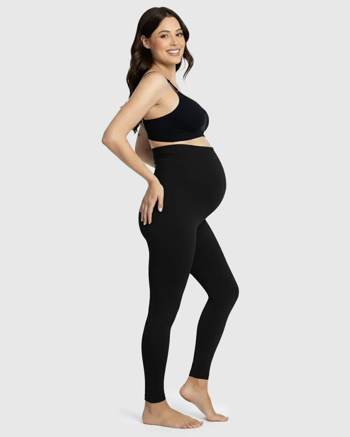 Smiling pregnant woman in black Bump Society Belly Support Stretch Maternity Leggings with an over-the-belly panel.