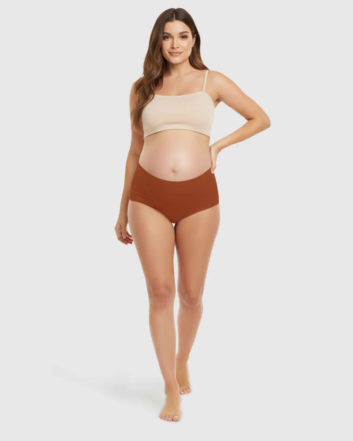 Pregnant woman modeling Bump Society seamless high-waist support maternity underwear in a warm brown color.