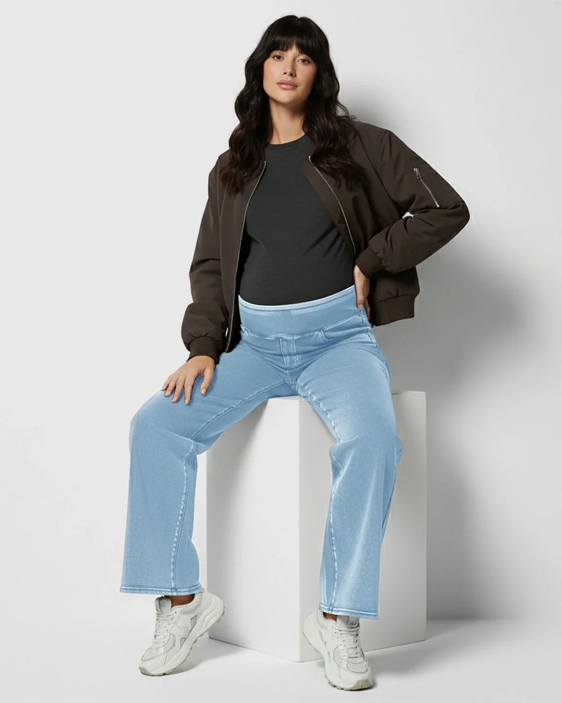 Woman in light blue high-waist wide-leg maternity denim jeans with a soft, stretchy waistband.