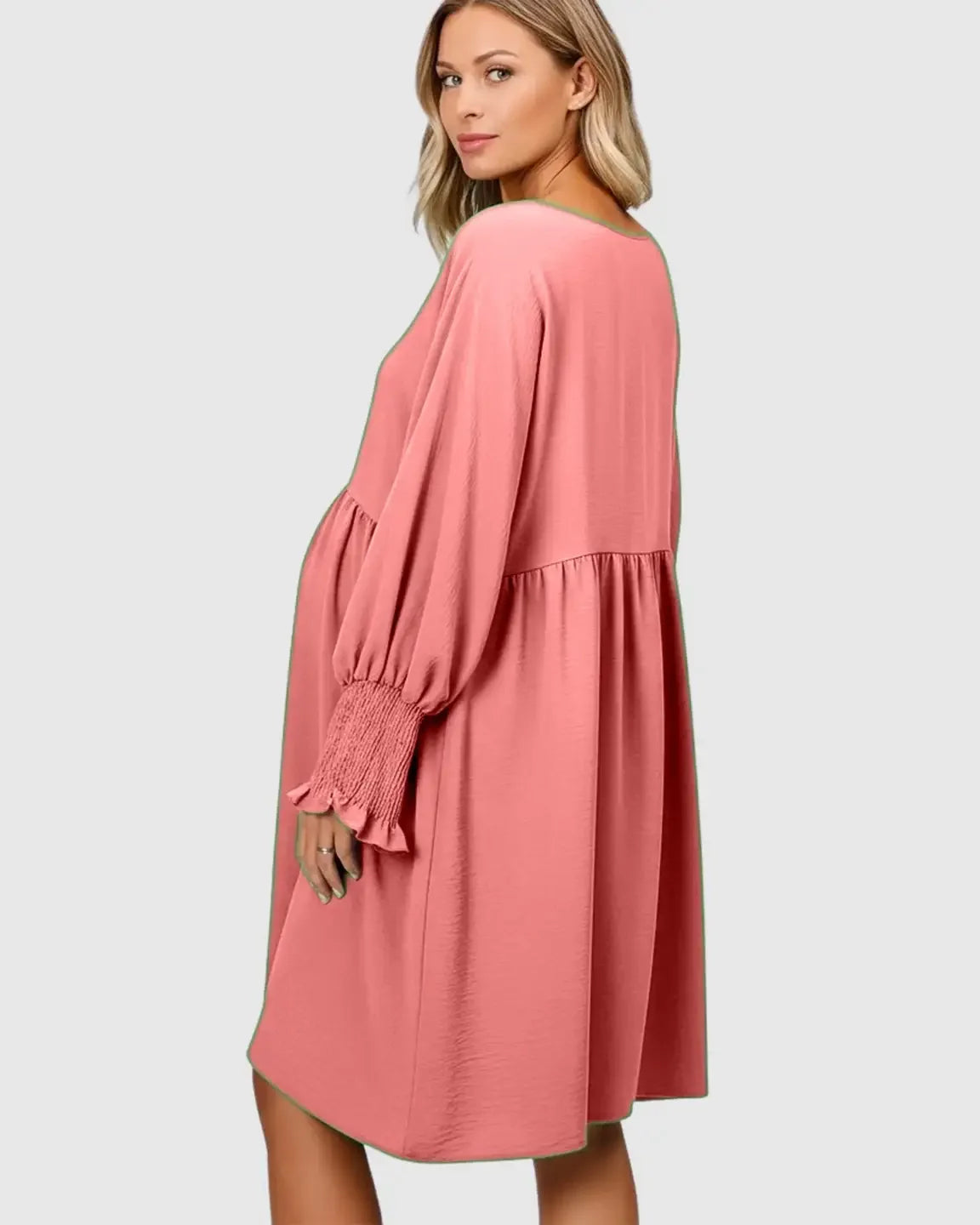 Pregnant woman in a pink flowy smocked sleeve casual dress with a round neckline and three-quarter sleeves.