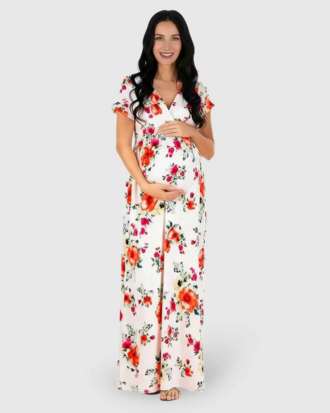 Smiling pregnant woman in a white floral V-neck short sleeve maternity maxi dress.