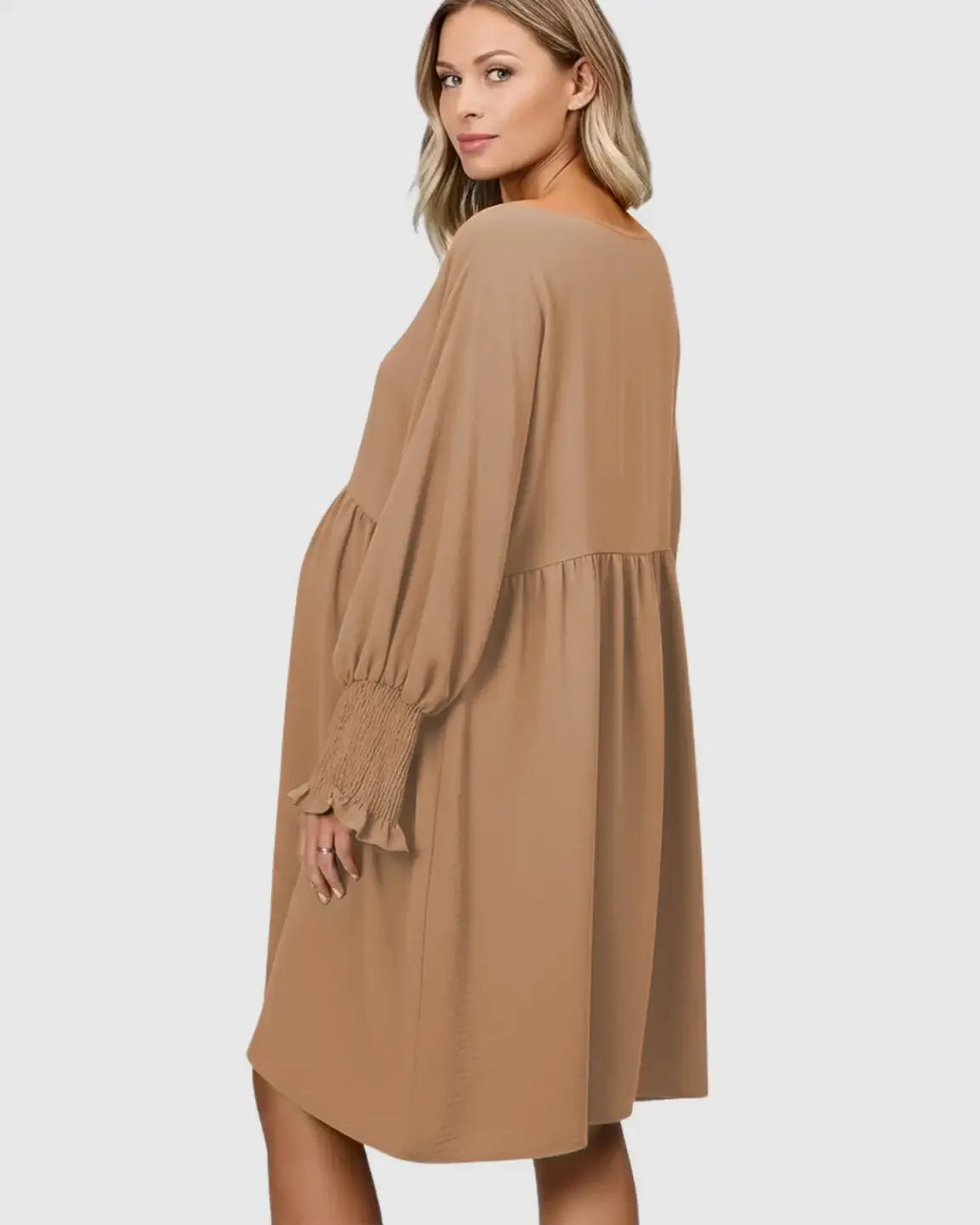 Maternity model in a flowy, smocked sleeve casual dress in a warm brown shade, featuring a relaxed fit.