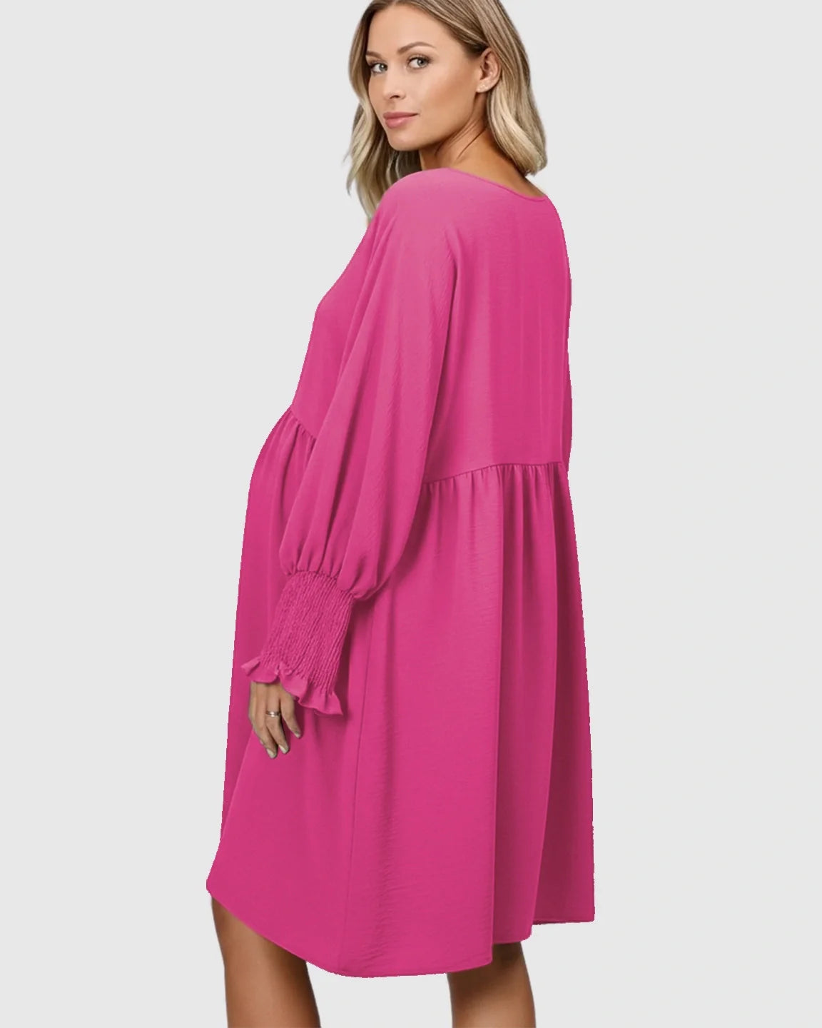 Maternity model in a bright pink smocked sleeve casual dress with a relaxed fit.