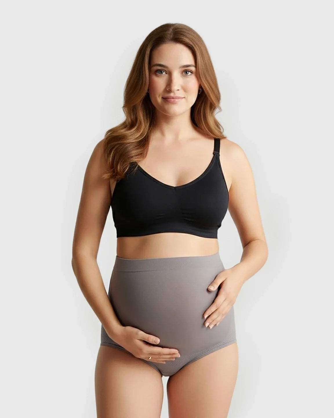 Pregnant woman wearing a black seamless maternity bra and gray high-waist seamless maternity panties.