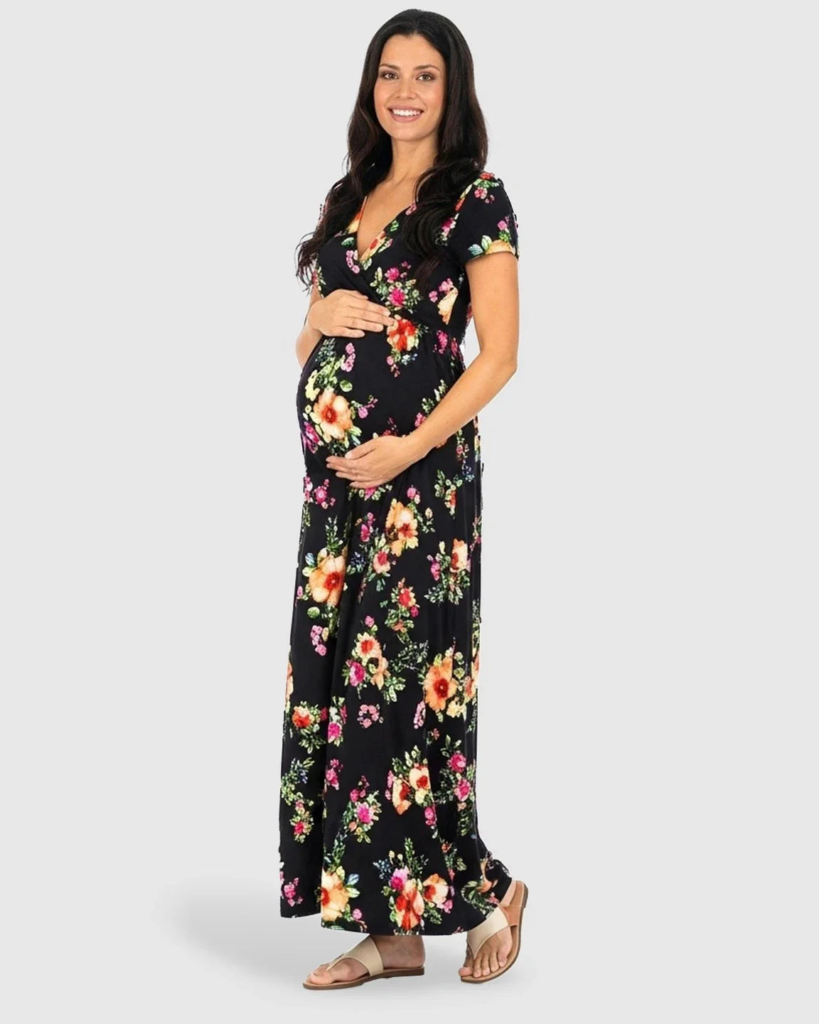 Smiling pregnant woman in a black floral V-neck short sleeve maternity maxi dress.