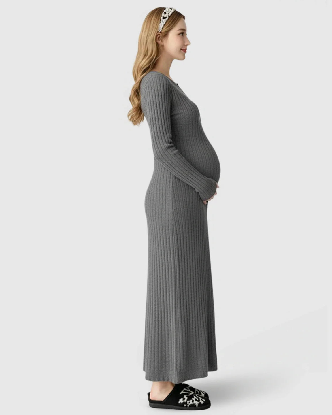 Pregnant woman in a gray ribbed knit A-line long sleeve maternity maxi dress, holding her bump.