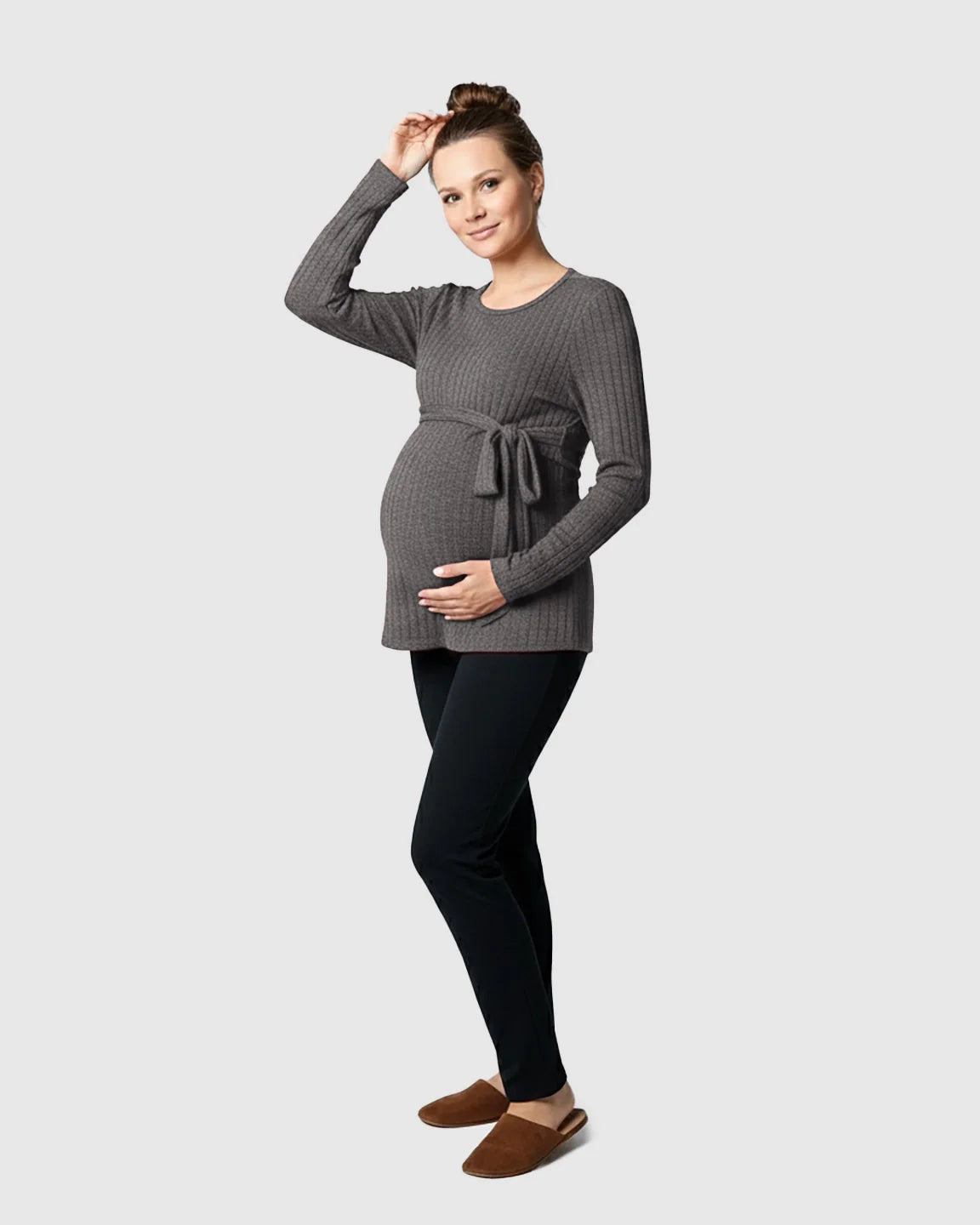 Pregnant woman in a gray ribbed tie-waist long sleeve maternity sweater and black pants.
