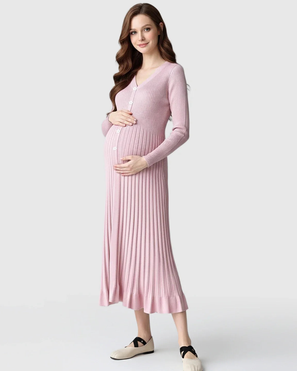 Smiling pregnant woman in a pink ribbed knit maternity midi dress with long sleeves and V-neck.